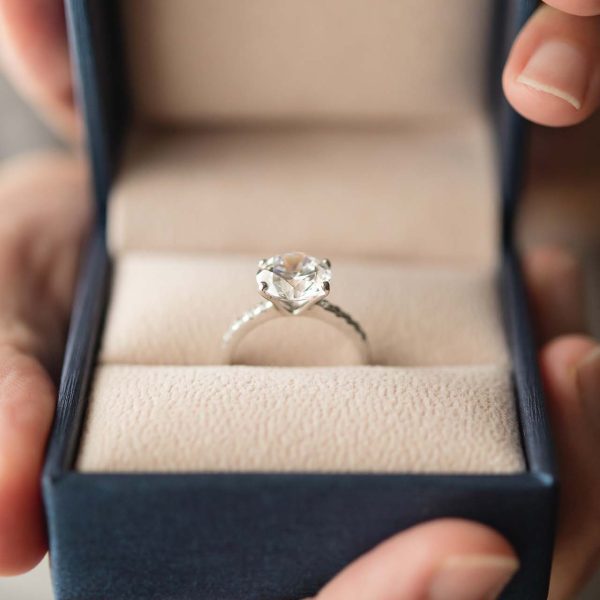 hands holding diamond ring in jewelry box